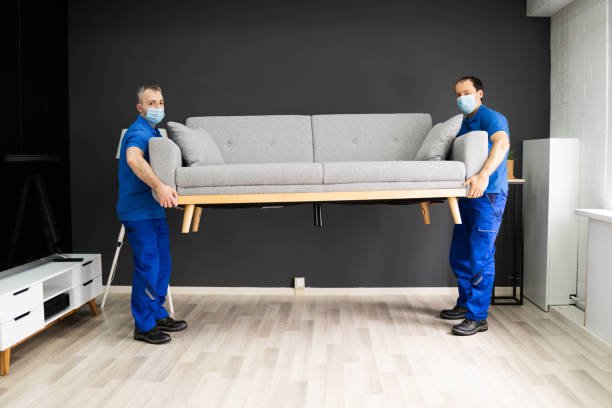 professional movers moving couch furniture in face mask